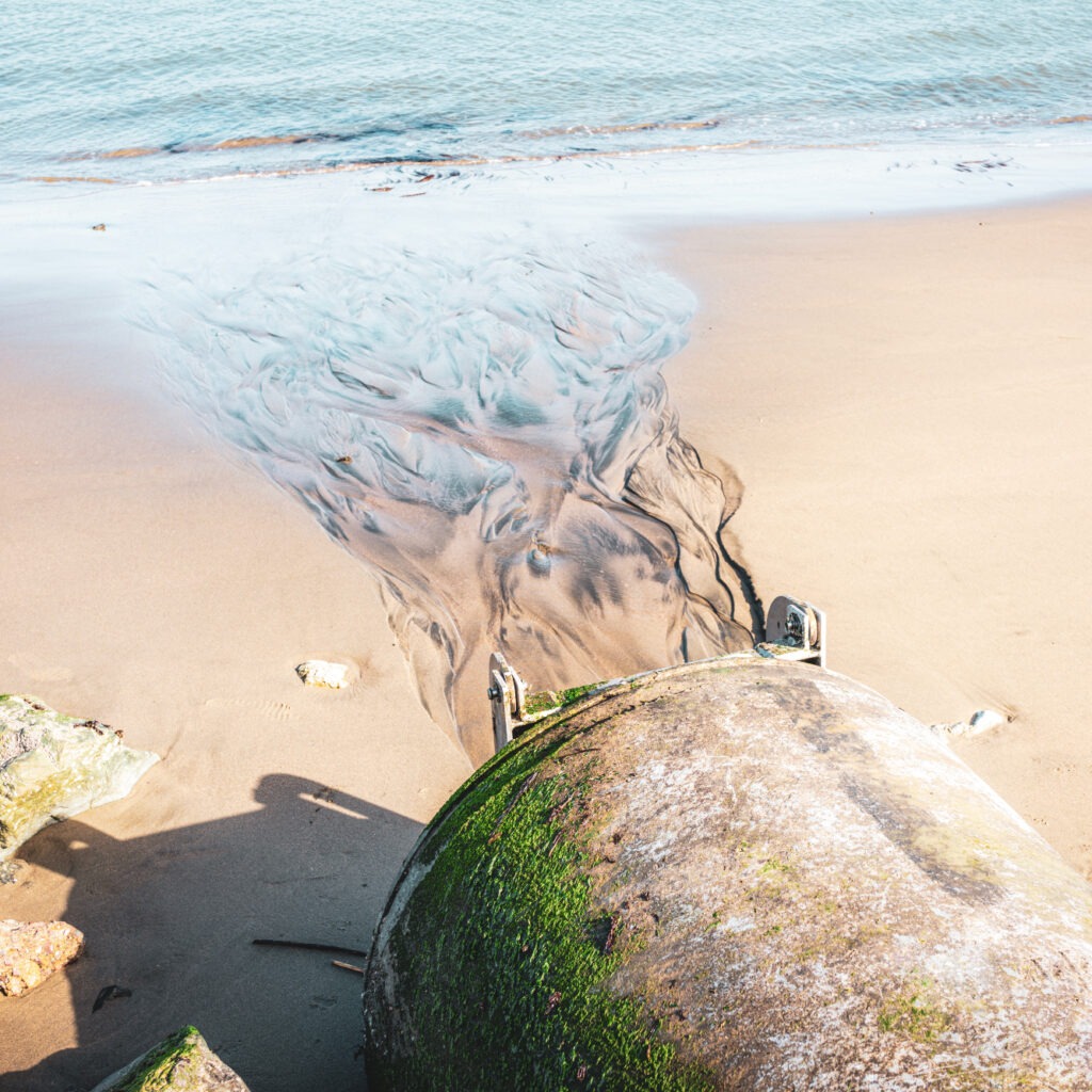 Wastewater pipe opens onto a natural waterway.