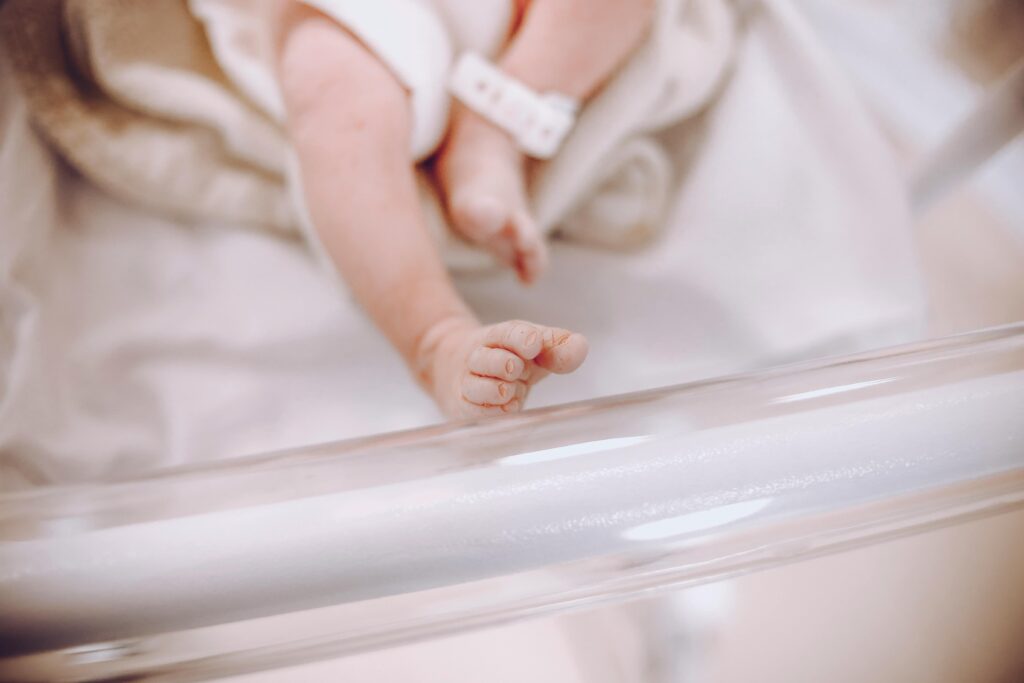 Close-up of a newborn baby's tiny foot resting in a hospital nursery.